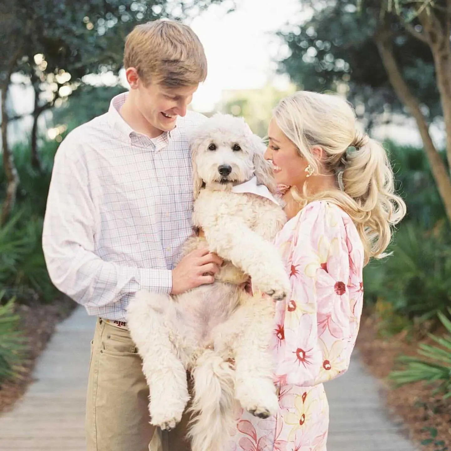 happy couple with mini ultra cream English teddy bear goldendoodle