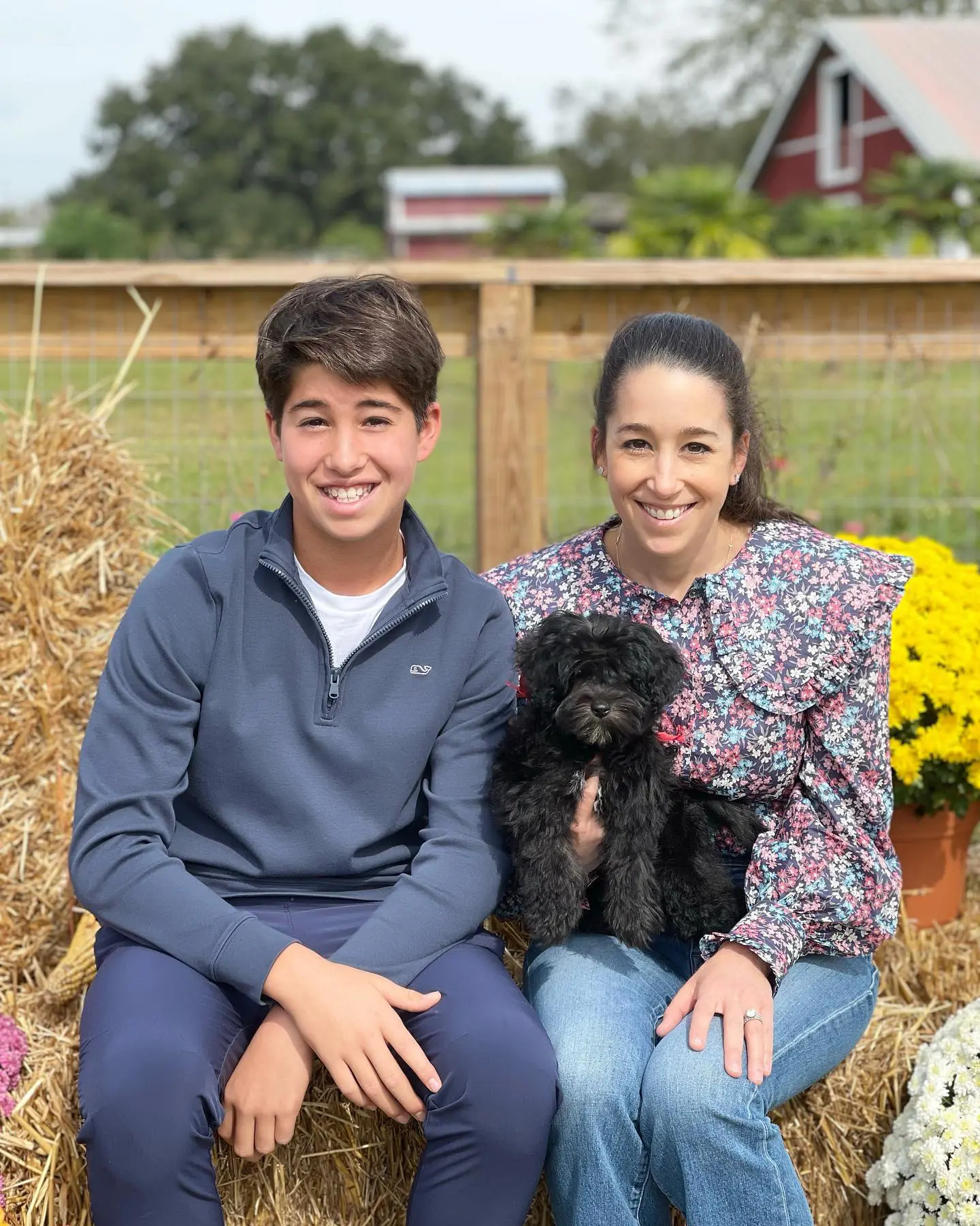 A Family holding their new black golden doodle puppy on Smeraglia farm