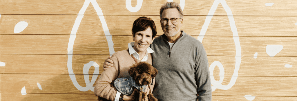 A couple holding their new Goldendoodle puppy