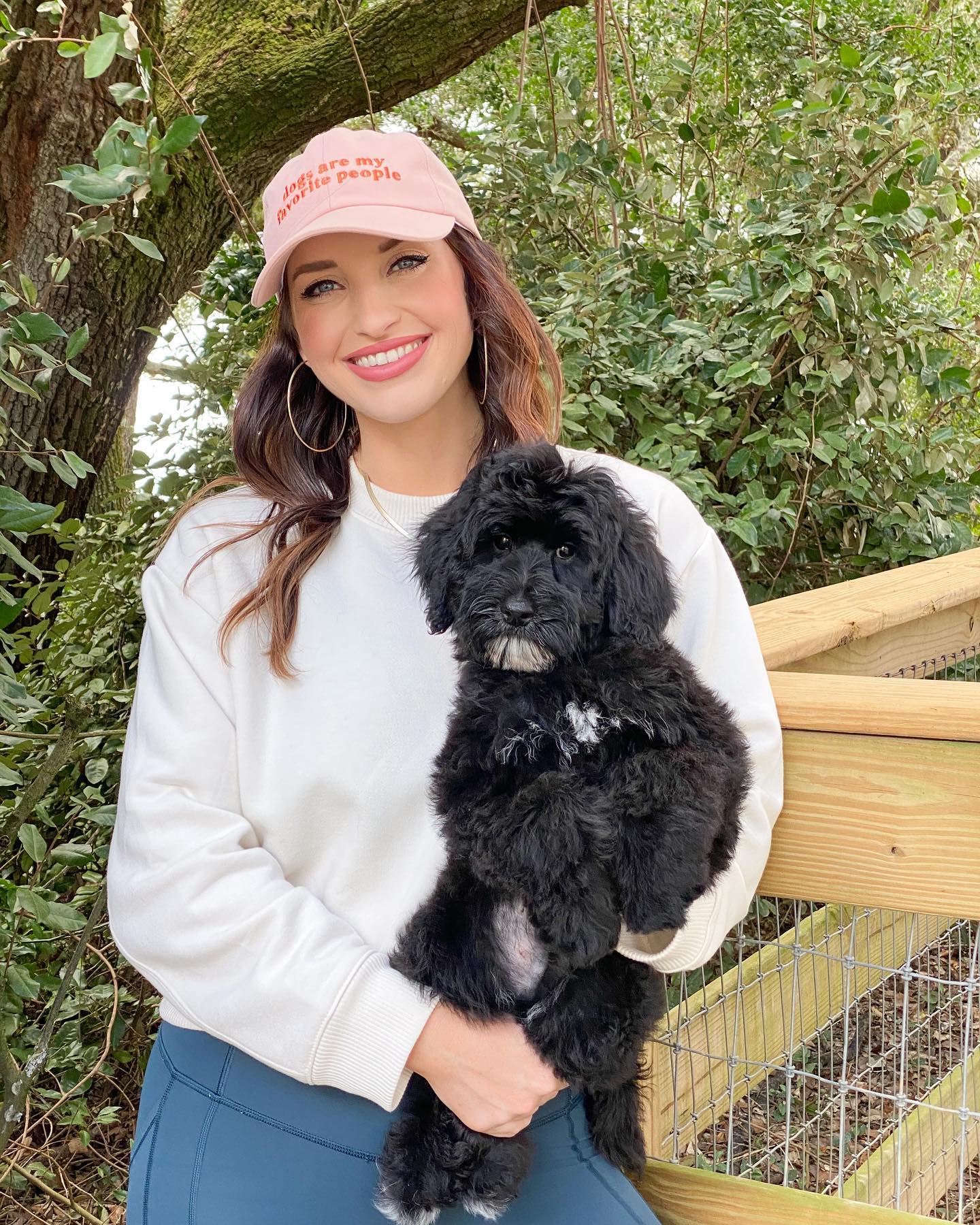 Taylor, an employee of Smeraglia Teddybear Goldendoodles, holding one of our black parti goldendoodles.
