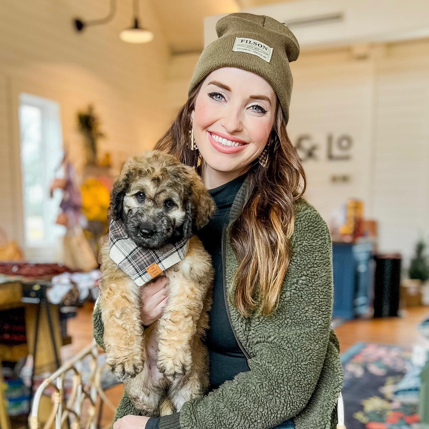 Taylor is pictured holding a golden doodle with a beautiful, unique color. This dog is definitely a rare find and is sure to be loved by anyone who meets it!
