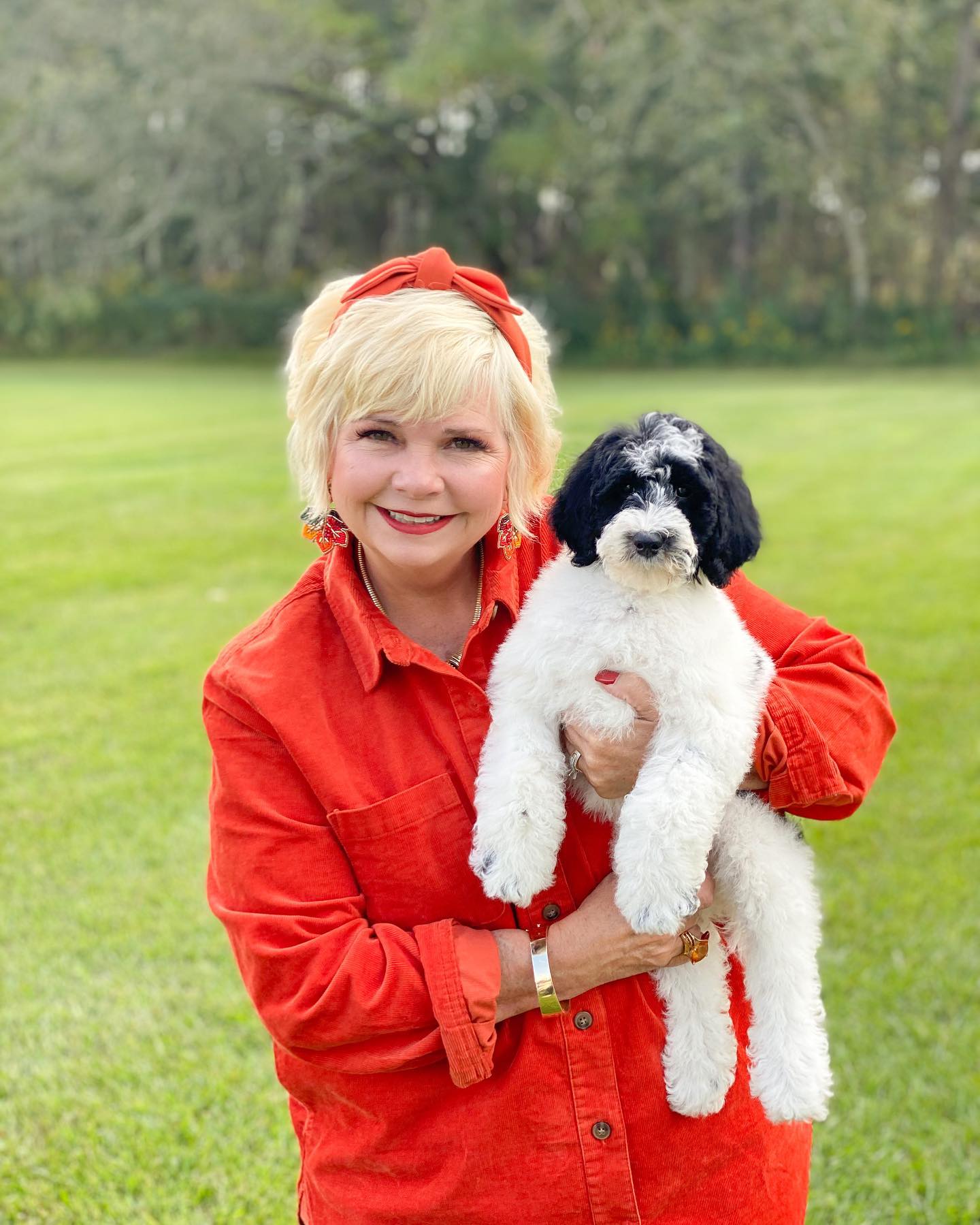 Sherri Smeraglia, professional dog breeder, holding a black and white parti golden doodle puppy.