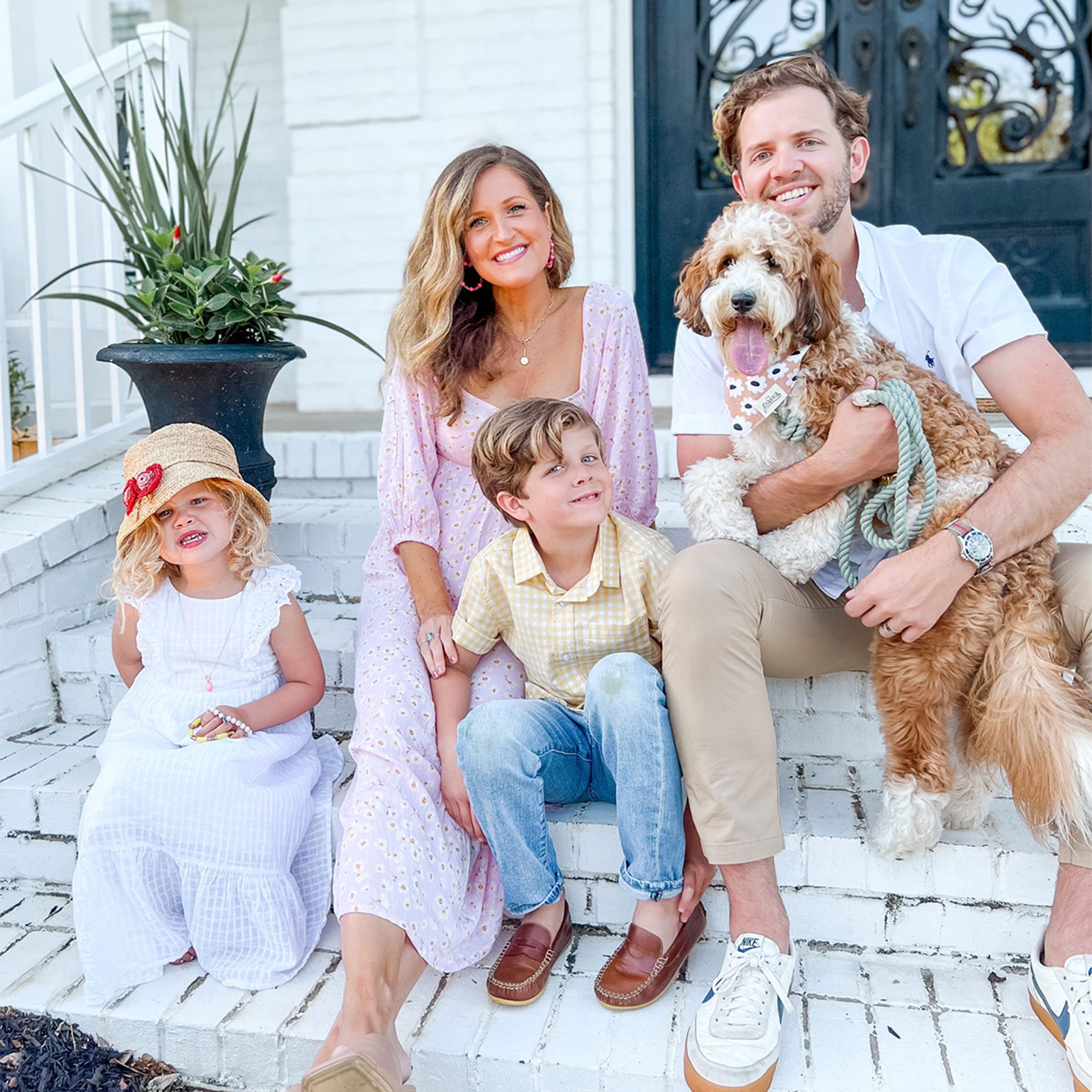 beautiful family holding a brown and white Twoodle puppy